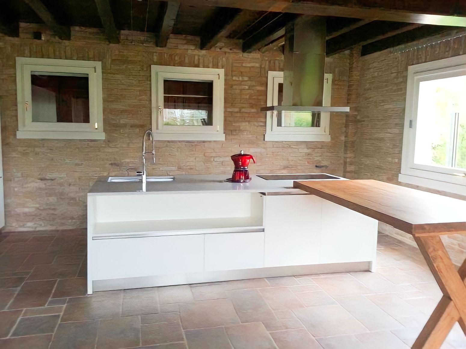 cucina moderna con isola centrale e vano a giorno Detto fatto: ampia isola contenitiva e funzionale, che svela un vano a giorno perfetto per degli oggetti d'arredo